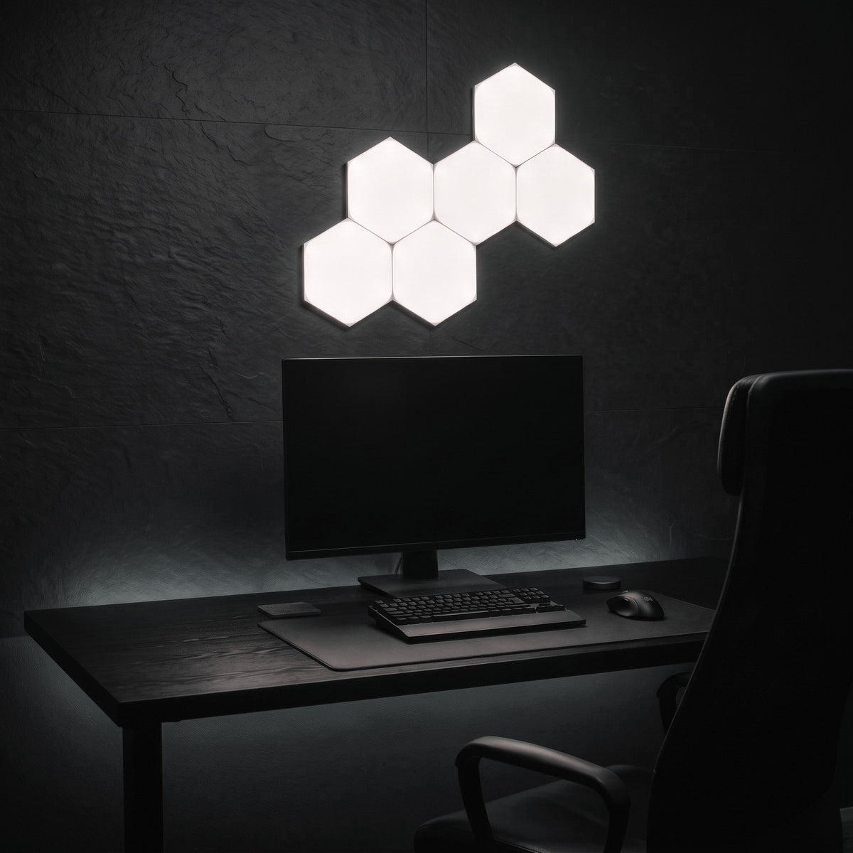 Six Aetheris Hexagon Light Panels in cool white on the wall above a desk and monitor