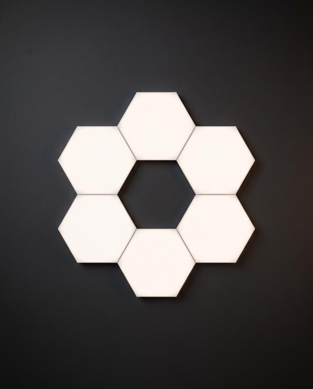 Six Aetheris Hexagon Light Panels in a ring layout glowing cool white on a graphite wall
